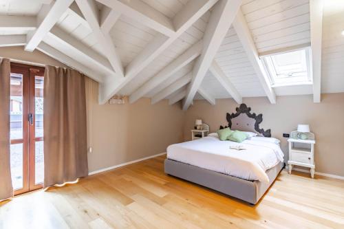 1 dormitorio con techos blancos y 1 cama grande en Mansarda Tra Le Risaie - Certosa di Pavia - by Host4U, en Torre del Mangano