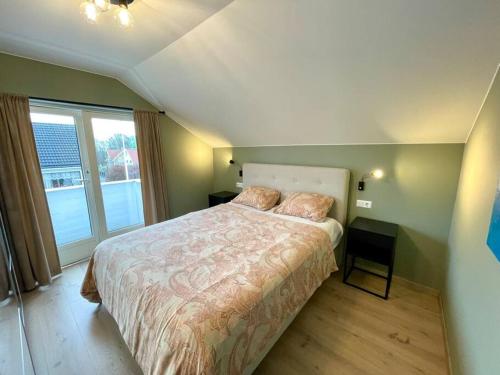 a bedroom with a large bed and a window at Central family twinhouse in Stavanger