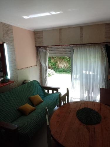 un soggiorno con divano verde e tavolo in legno di Frente al golf a Mar del Plata