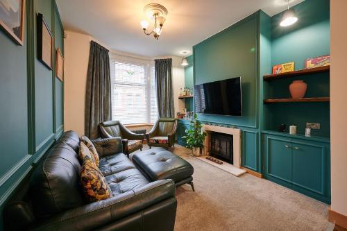 a living room with a leather couch and a television at Host & Stay - 19 Garswood in Liverpool