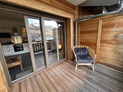 un porche grillagé avec une chaise et une cuisine dans l'établissement Châtel: Appartement neuf 4 pers, terrasse, parking, local à skis, wifi, ménage inclus - FR-1-198-261, à Châtel