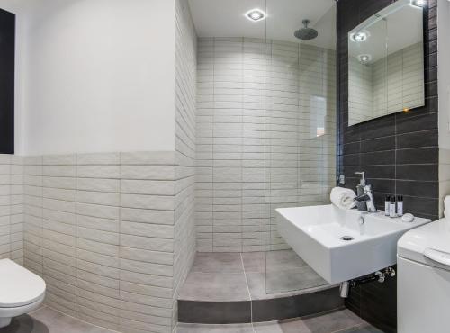 a bathroom with a white sink and a toilet at Apartment Chmielna Street - Central Station in Warsaw
