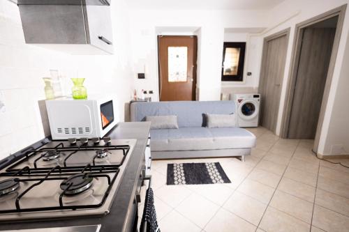Il dispose d'une cuisine et d'un salon avec une cuisinière et un canapé. dans l'établissement Delightful Apartment Close To The Center, à Lido di Ostia