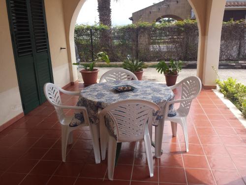 un patio con mesa y 4 sillas en Appartamento Santangelo en Porto Palo