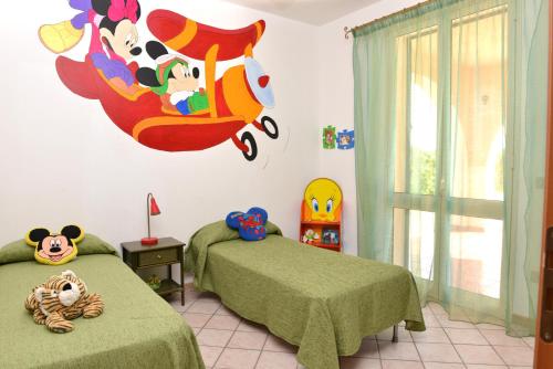 Un dormitorio con 2 camas y una pared con un cartel de Disney en Appartamento Santangelo en Porto Palo