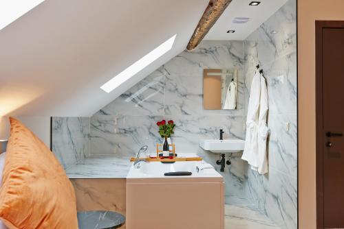 a bathroom with a white marble wall at Hotel Les Ecrins in Brussels