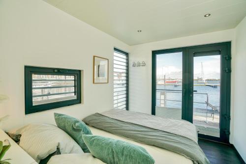 a bedroom with a bed and a window at Exklusives Ostsee-Hausboot, Küche mit Spüler, Tv, große Sonnenterrasse, 3x kostenfreie Kfz-Parkplätze, Klimaanlage, bis zu 6 Personen, 2x Bäder, Waschmaschine in Boltenhagen