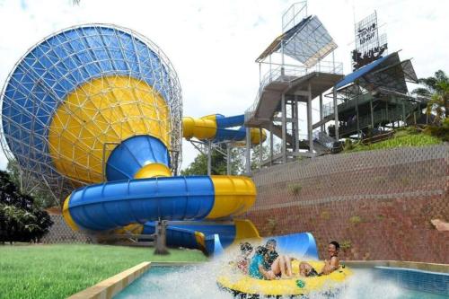 a group of people riding on a water slide at a water park at Casa Savoy - A Famosa Resort Melaka in Kampong Alor Gajah