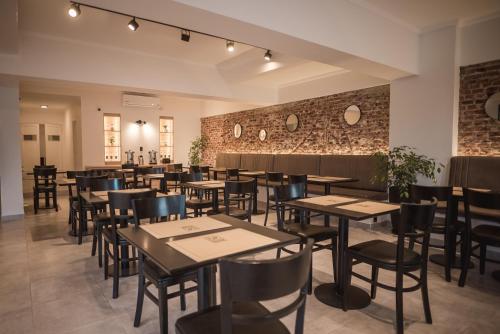 een restaurant met tafels en stoelen en een bakstenen muur bij Hotel Libertad in Villa Carlos Paz