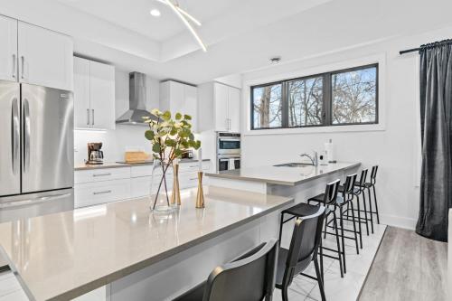 a kitchen with white cabinets and a large island with bar stools at Rent 8Bed 8Bath DowntownLondon Parking Wi-Fi in London