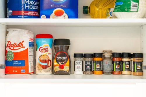 a shelf with various spices and other food items at Rent 8Bed 8Bath DowntownLondon Parking Wi-Fi in London