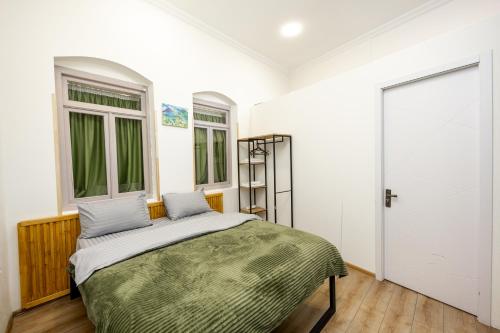 a bedroom with a bed and two windows at The heart of the ancient district 3BD-2BATH apartament in Tbilisi City