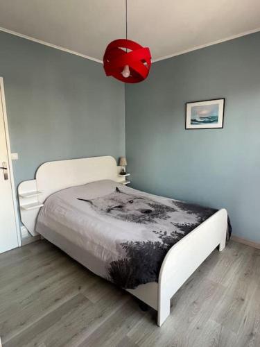 - un lit blanc dans une chambre avec une lampe rouge dans l'établissement Appartement à deux pas de la mer, à Pléneuf-Val-André