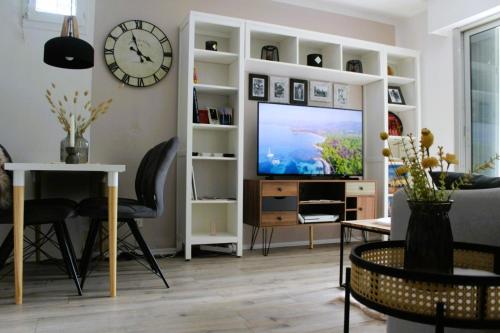 un salon avec une télévision et un canapé dans l'établissement Soleil de Fréjus au Lagonbleu, à Fréjus