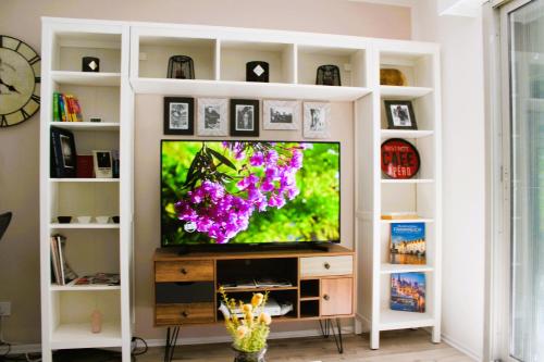 - un salon avec une télévision dans une étagère blanche dans l'établissement Soleil de Fréjus au Lagonbleu, à Fréjus