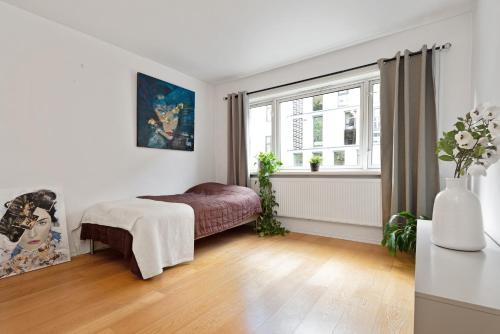 a white bedroom with a bed and a window at Large apartment - Luxurious neighborhood - 8 pax in Oslo