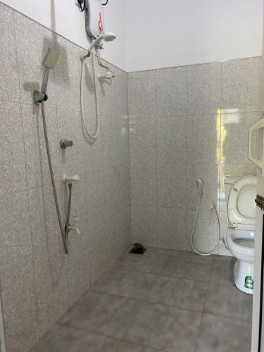 a bathroom with a shower and a toilet at Wild Bee Safari Lodge in Udawalawe