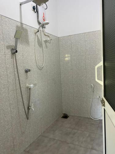 a bathroom with a shower with a shower head at Wild Bee Safari Lodge in Udawalawe