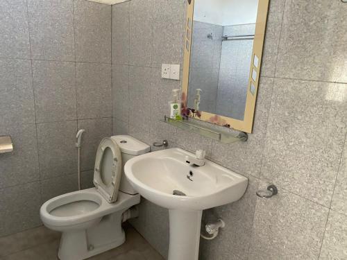 a bathroom with a toilet and a sink and a mirror at Wild Bee Safari Lodge in Udawalawe
