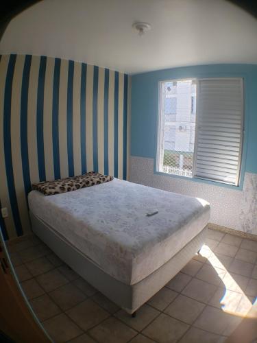 um quarto com uma cama num quarto com uma janela em Entre as praias em Florianópolis