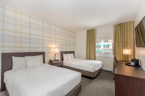 a hotel room with two beds and a desk at Ohio House Motel in Chicago