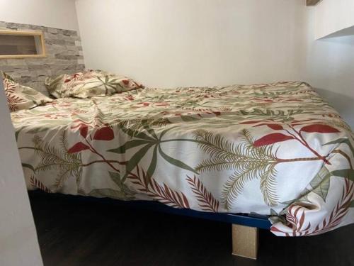 a bed with a comforter on it in a bedroom at Joli loft rénové in Payré