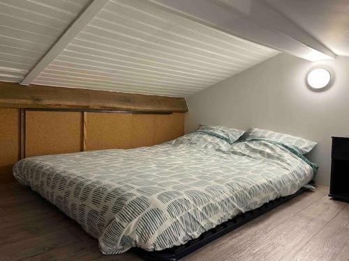 a bedroom with a large bed with a white comforter at Joli loft rénové in Payré