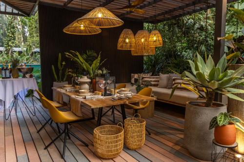 a patio with a table and chairs and a couch at Exôtico Beach Hotel in Puerto Viejo