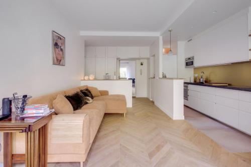 een woonkamer met een bank en een keuken bij Le Souci du Détail in Paris in Parijs