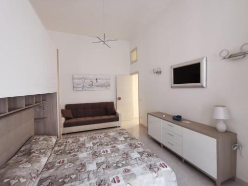 a bedroom with a bed and a couch at Coral - La Pescheria Casa Vacanze in Gaeta