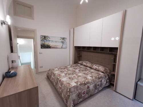 1 dormitorio con 1 cama, mesa y armarios en La Pescheria Casa Vacanze, en Gaeta