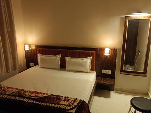 a bed with two pillows and a mirror in a room at Happy Homes in Varanasi