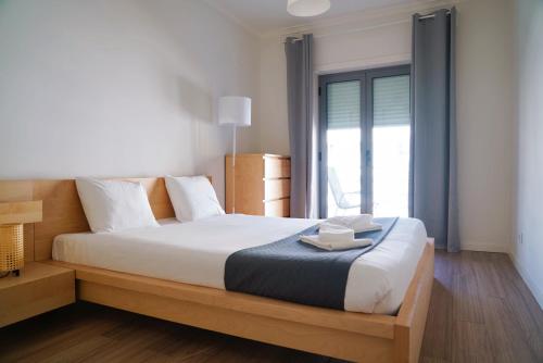 a bedroom with a large bed with a large window at Always on the way - Road Home in Montijo, Lisbon in Montijo