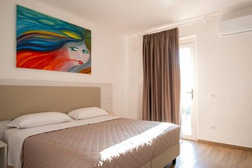 a bedroom with a bed with a painting on the wall at Laurus Cilento Relax BeB in Laureana Cilento