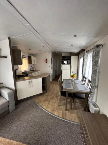 a kitchen and dining room with a table in a caravan at Lovely caravan at Martello Beach Holiday Park Sv14 in Jaywick Sands
