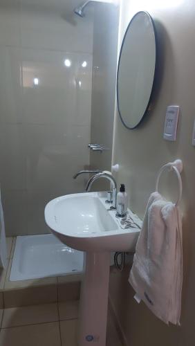 W białej łazience znajduje się umywalka i lustro. w obiekcie A&G departamento moderno, zona céntrica de Tucumán w mieście San Miguel de Tucumán