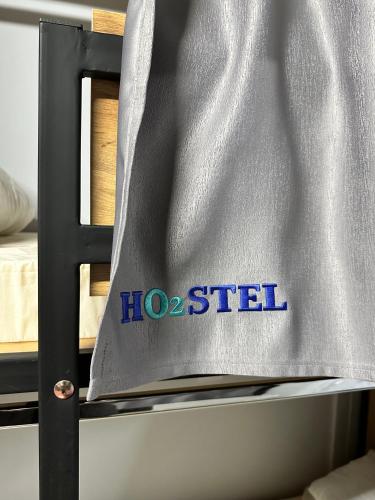 a close up of a bed with a hostetter sign on it at Hostel O2 in Almaty