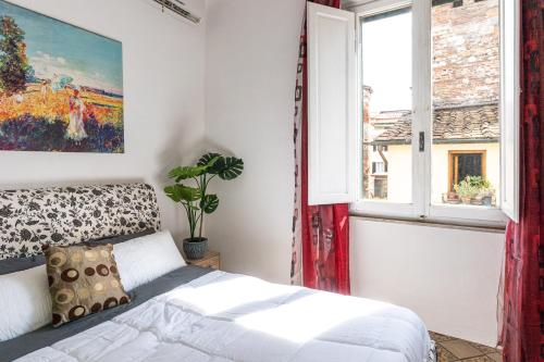 een slaapkamer met een bed en een raam bij Historic apt in the center of Lucca with Balcony in Lucca