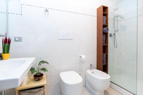 La salle de bains est pourvue de toilettes, d'un lavabo et d'une douche. dans l'établissement Historic apt in the center of Lucca with Balcony, à Lucques