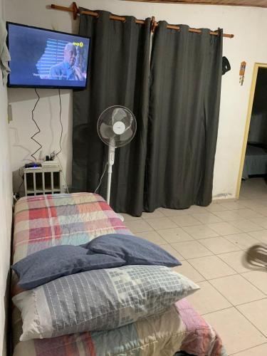 1 dormitorio con 1 cama y TV en la pared en departamento en san rafael mendoza en San Rafael