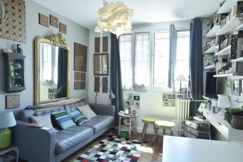 a living room with a couch and a table at The Atypical - 1 Bedroom in Canal de l'Ourcq in Paris