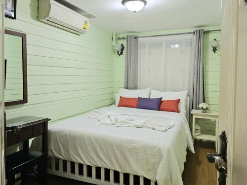 um quarto com uma cama branca e almofadas coloridas em W home The Thai-style tranquil and cozy villa em Banguecoque