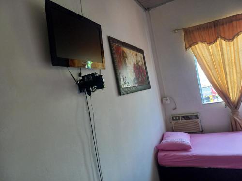 Habitación con TV de pantalla plana en la pared en Hotel da Gaucha, en Cruzeiro do Oeste