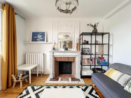 een woonkamer met een bank en een open haard bij Le Rayon de Soleil de Maison-Alfort in Maisons-Alfort