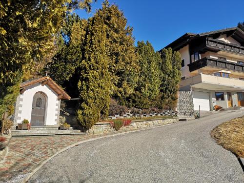 a house with a small chapel on the side of a road at Ferienwohnung Tanzer in Ellbögen