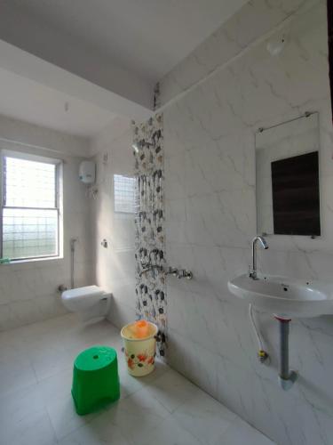 bagno bianco con lavandino e servizi igienici di Vividora a Nagpur