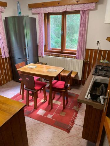 a kitchen with a wooden table and chairs and a stove at Chata u Lucky in Liptovský Mikuláš
