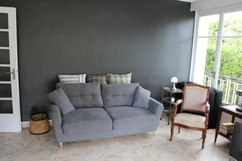 a living room with a gray couch and a chair at Exceptionnel, 5' du village de cassis, vue féerique, piscine, parking in Cassis
