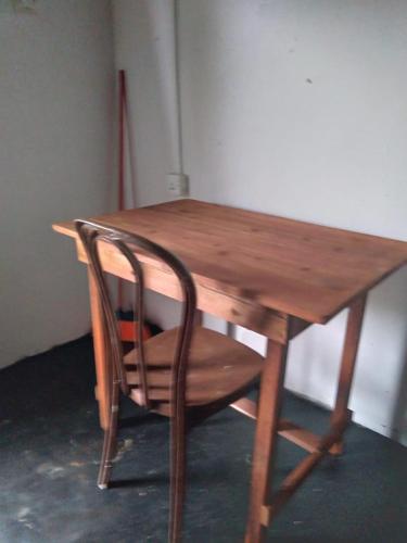 une table en bois avec une chaise en bois à côté dans l'établissement SENN Homestay, à Polonnâruvâ
