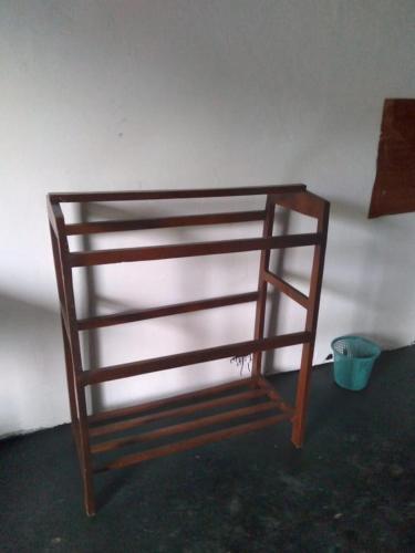 - une étagère en bois dans une chambre avec un seau dans l'établissement SENN Homestay, à Polonnâruvâ
